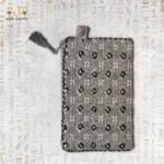 Handwoven Luxury Surprise clutch featuring delicate black and white beaded floral patterns with a tassel zipper closure.