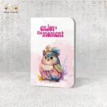 Magical Moment notebook with vibrant watercolor bird and “Enjoy the moment” text, made in Egypt