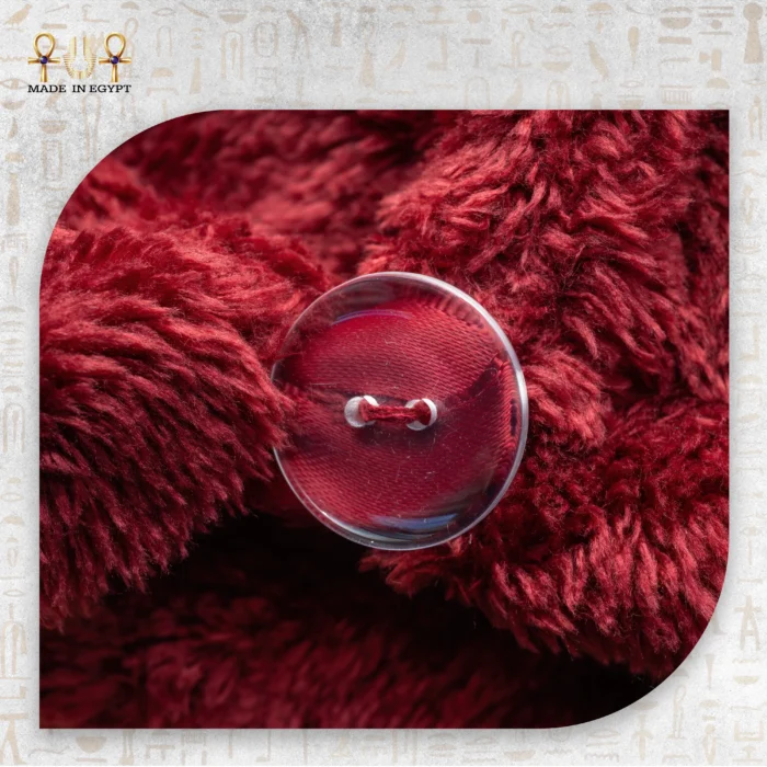 Close-up of the red microfiber towel's button fastening with soft, plush texture.