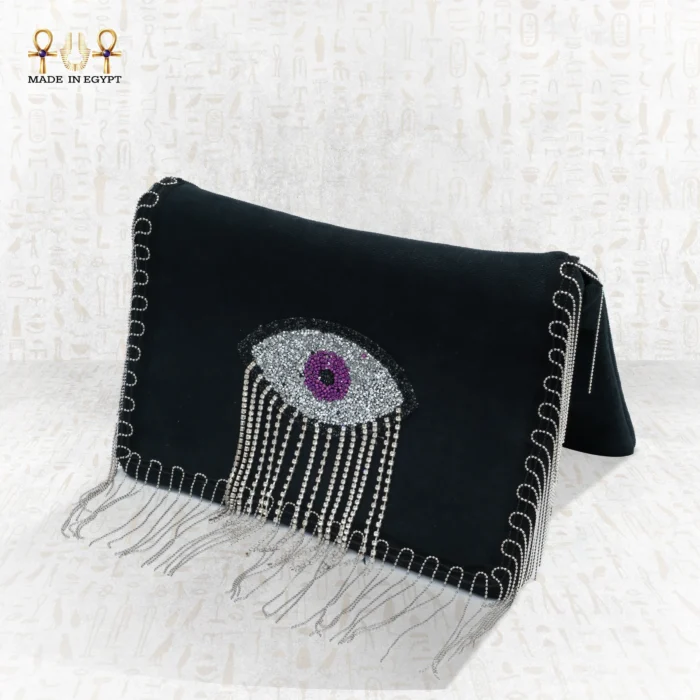 Side view of the Mysterious Gaze bag featuring a beaded eye motif with silver fringe on a black velvet clutch.