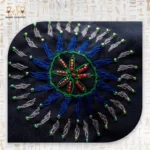 Close-up of the embroidered floral pattern on the Night Delight bag, showcasing vivid blues, greens, and reds with intricate stitching.