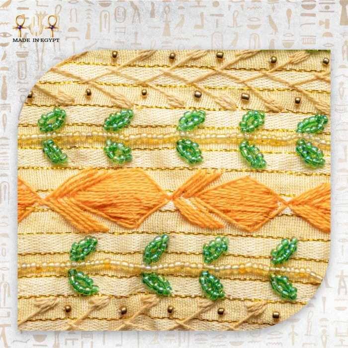 Close-up of the embroidery on the Nile Joy pouch showing orange thread and green beads.