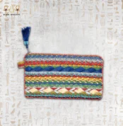 Nubian Delight pouch with intricate multi-colored embroidery, featuring red, blue, yellow, and green beads with a blue tassel.