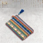 Nubian Delight pouch side view with multi-colored embroidery, featuring blue, green, red, and yellow threads, and a blue tassel.