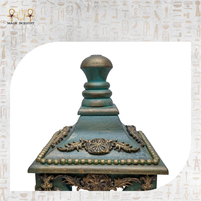 Close-up of the hand-carved top of a small green Royal Heritage Lantern with golden detailing.