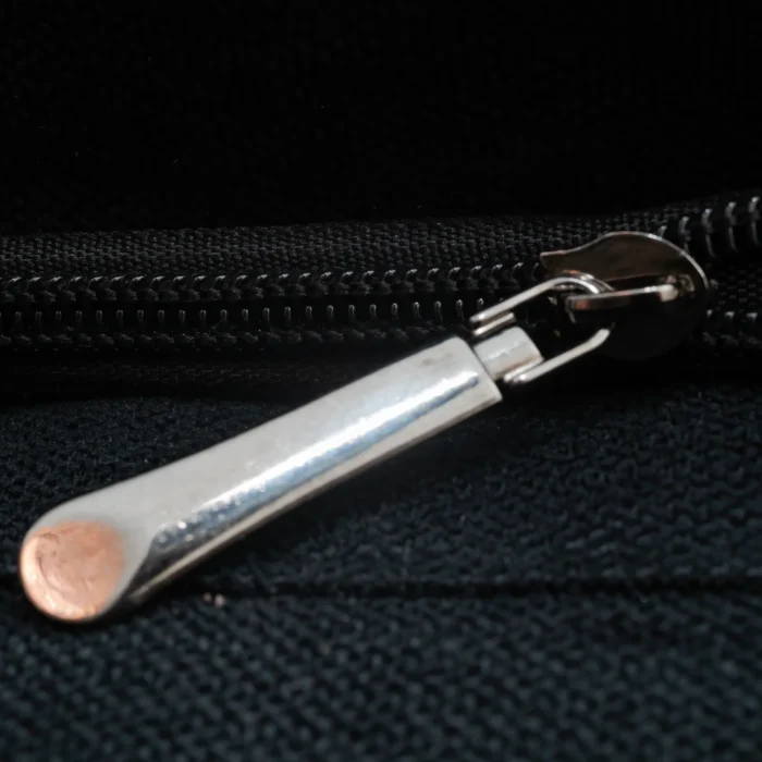 Close-up of the Royal Shadow bag showing silver zipper detail on black fabric