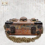 Flat view of Secret of the Pharaonic Scarab bag with carved scarab and brass details.