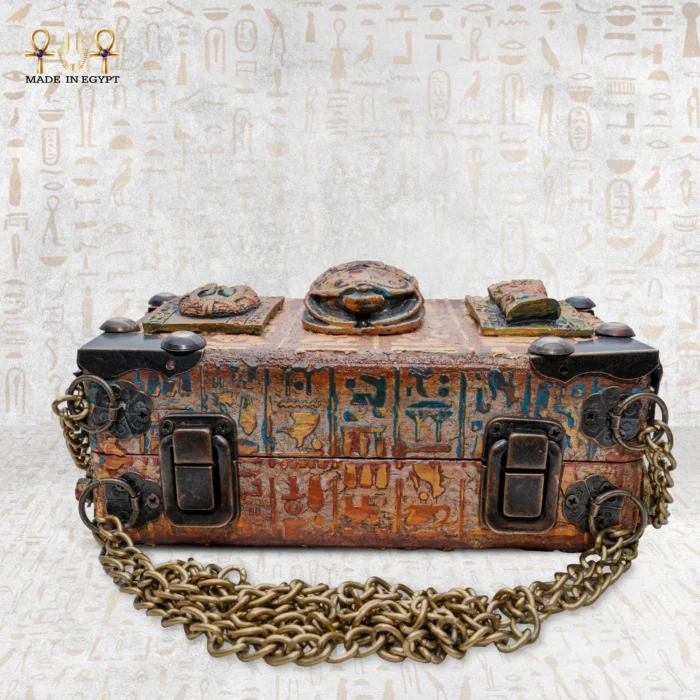 Flat view of Secret of the Pharaonic Scarab bag with carved scarab and brass details.