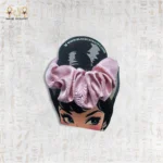 Shiny Tie pink satin scrunchie displayed on branded card with cartoon design.