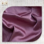 Pink satin pillowcase fabric close-up showing soft sheen and smooth surface.