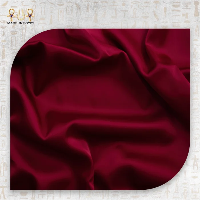Red satin pillowcase fabric close-up showing smooth and shiny texture.