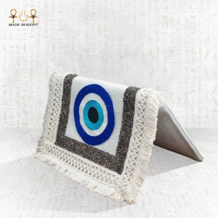 Side view of the Guardian Eye bag with blue evil eye embroidery, silver-thread borders, and cream fringe details.