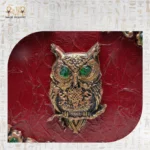 Close-up of owl centerpiece on The Zodiac Sage handcrafted wooden bag with green gemstone eyes.