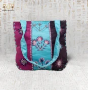 Handcrafted embroidered tote bag with vibrant flower motifs in purple, blue, and pink, showcasing Egyptian craftsmanship.