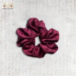 Velvet Rose satin scrunchie in deep burgundy color on neutral background.