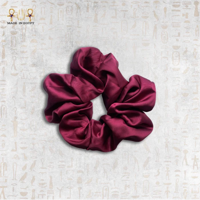 Velvet Rose satin scrunchie in deep burgundy color on neutral background.