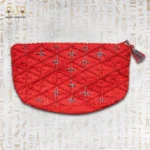 Top view of a red handcrafted wind bag with intricate beadwork, featuring a geometric floral design in red and blue.