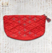 Top view of a red handcrafted wind bag with intricate beadwork, featuring a geometric floral design in red and blue.