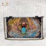 Handcrafted “Winged Scarab” Egyptian bag with golden wings and turquoise scarab design on front.