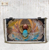 Handcrafted “Winged Scarab” Egyptian bag with golden wings and turquoise scarab design on front.
