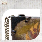 Close-up of antique brass corner and chain detail on Winged Scarab bag.