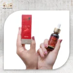 Chili Essential Oil, 30ml, bottle held with packaging box visible.
