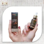Cloves Essential Oil, 30ml, bottle held with packaging box visible.