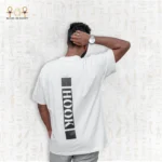 Back view of a man wearing a white Minimal Tee with large vertical black "HOOK" print, one hand on head.