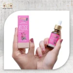 Rose Essential Oil 30ml bottle with pink packaging, held in hand. 100% concentration, from the Land of Pharaohs.