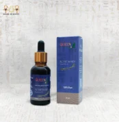 Hands holding Queen rosemary essential oil bottle and packaging box against a light fabric background.