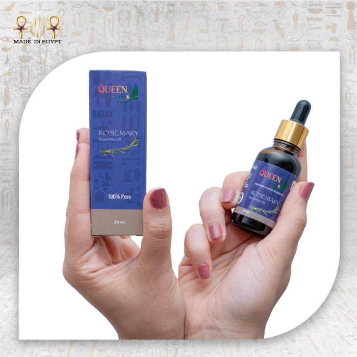 Hands holding Queen rosemary essential oil bottle and packaging box against a light fabric background.
