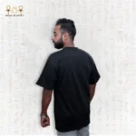 Man wearing a black Skyline Tee, full back view, standing with arms relaxed.