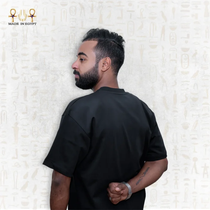 Close-up side back view of a man wearing a black Skyline Tee, hands behind his back, focusing on the upper body details.